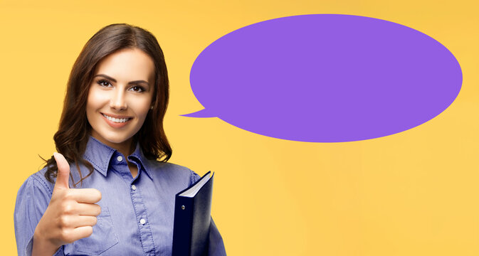 Happy smile business woman hold black folder show point thumb up hand sign gesture. Cute brunette businesswoman, isolated yellow background. Vibrant purple empty free text space mockup speech bubble