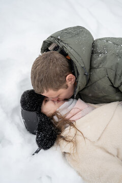 Romantic couple enjoying winter snowfall together