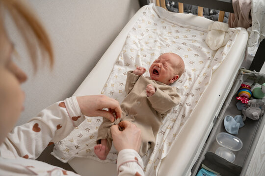 Newborn baby being dressed on a changing table
