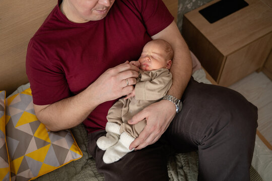 Father cradling newborn at home in peaceful moment