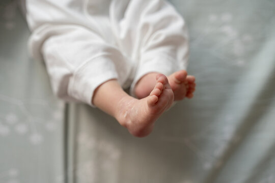 Adorable newborn feet resting on soft blanket