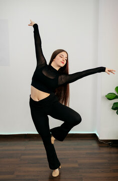 Graceful dancer in ballet studio performing elegant pose
