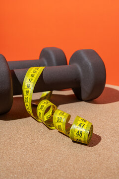 Dumbbells and measuring tape for fitness goals
