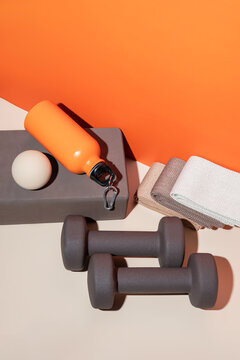 Fitness equipment arrangement with dumbbells and yoga block