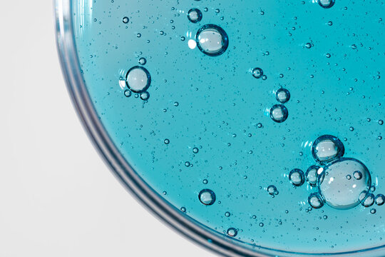 Blue liquid texture in petri dish with air bubbles