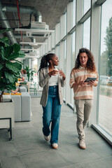Diverse coworkers walking and discussing in modern office