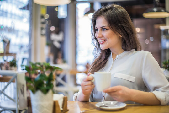 Woman enjoying coffee in a cozy cafe setting