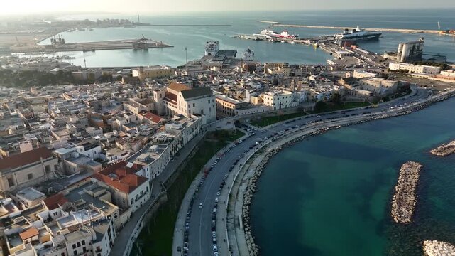 Aerial panoramic view of Bari, Italy on the Adriatic Sea coast with marina, yachts, lighthouse, waterfront promenade, historic architecture and modern cityscape under summer sunlight
