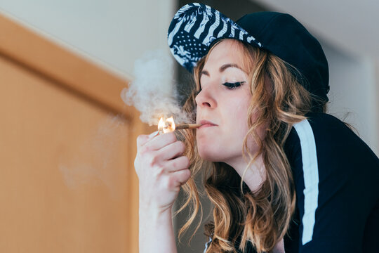 Woman smoking cannabis joint indoors