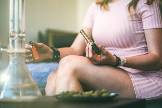 Woman relaxing with cannabis pipe and marijuana