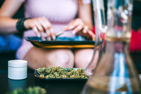 Woman rolling cannabis joint in a relaxed setting