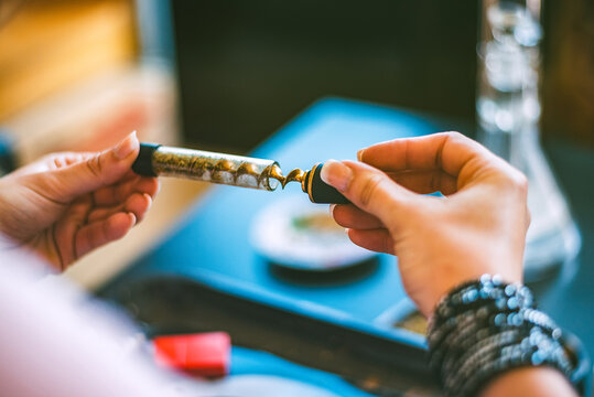 Woman preparing marijuana in a glass blunt