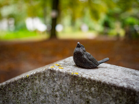 steinerner Spatz auf Grabstein
