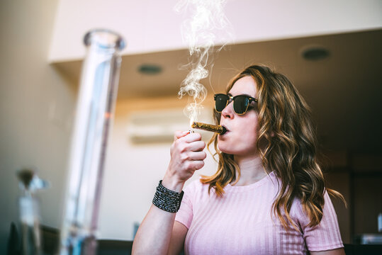 Woman enjoying cannabis with a glass blunt