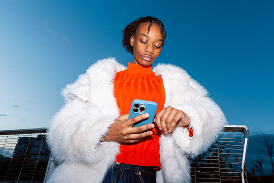 Gen Z girl in vibrant attire using smartphone