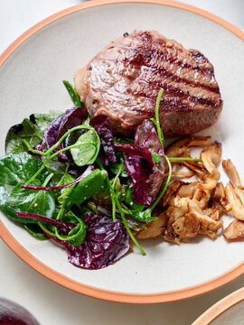 Sliced chuck steak with salad and mushrooms