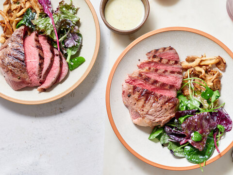 Sliced chuck steak with salad, mushrooms.