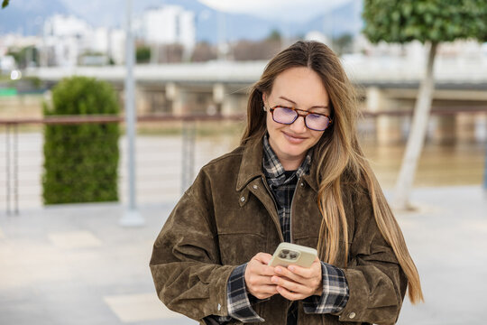 Woman using smartphone outdoors on a casual day