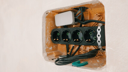 Fototapeta premium Electrical outlet installation in progress, showing wiring and socket housing within a wall