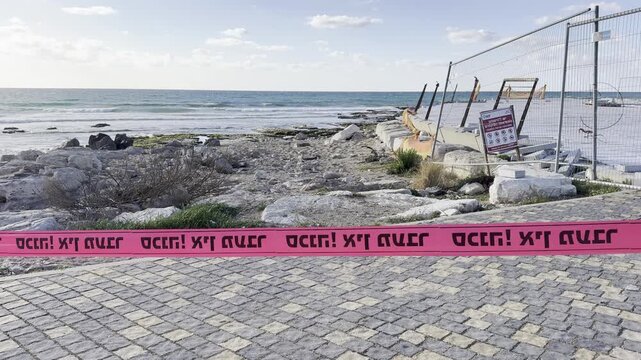 Prohibition tape fluttering in the wind, blocking beaches on the Mediterranean coast of Israel near Haifa during wartime when access to the beaches is forbidden