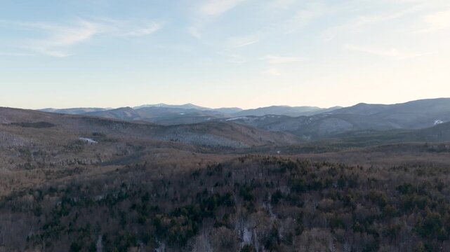 4K winter drone video of the snowy green mountains of Vermont and ski area trails covered in snow in the distance. Killington, New England, USA.