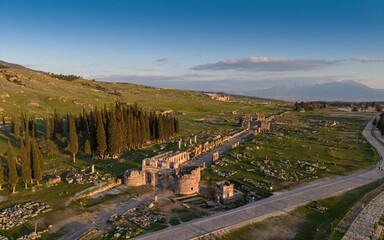 Obraz premium Aerial drone view of Hierapolis Antik Kenti and the famous Pamukkale travertines in Denizli, Turkey, showing ancient ruins, Roman theater, columns, and scenic landscape from above.