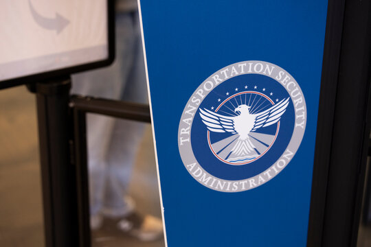 San Jose, California, USA - November 22, 2025: A traveler waits in line behind a TSA logo at the San Jose International Airport.