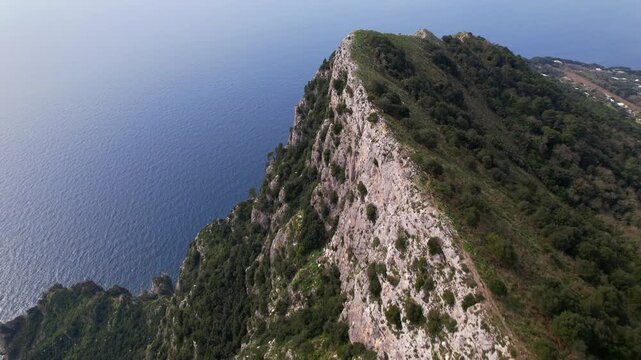Aerial view of Monte Solaro and the blue sea of ​​Capri. Stunning drone footage of the highest point on the island of Capri, overlooking the endless Mediterranean Sea.