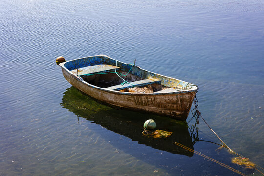 Small fishing boat moored and floating on calm water