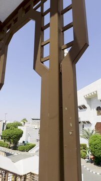 A view of Masjid Aisha (Taneem Mosque) in Makkah, Saudi Arabia, framed by a aluminium trellis. This iconic white mosque serves as a primary Miqat station for Muslims entering Ihram to perform Umrah.