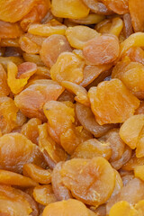 Dried apricots close-up texture at market stall showing natural orange fruit slices