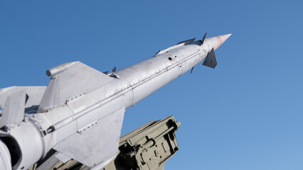 Missile Tail Section Captured In Detail, Closeup Of Fins, Hinges And Nozzle, Weathered Paint And Rivets Showing Maintenance History, Workshop Lighting With Warm Sunlight And Shadow, Suggests