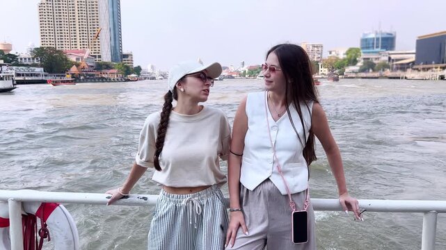 Friends in casual outfits spend time on board, admiring views of an Asian metropolis.