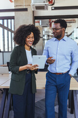 Business Colleagues Discussing Project On Tablet In Modern Office During Casual Meeting And...