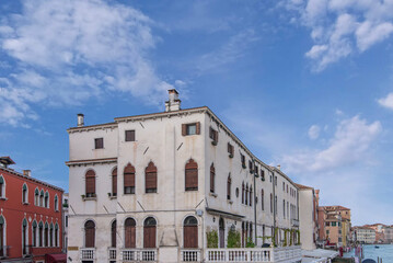 Historic white palazzo facade with arched windows and wooden shutters © Sergey
