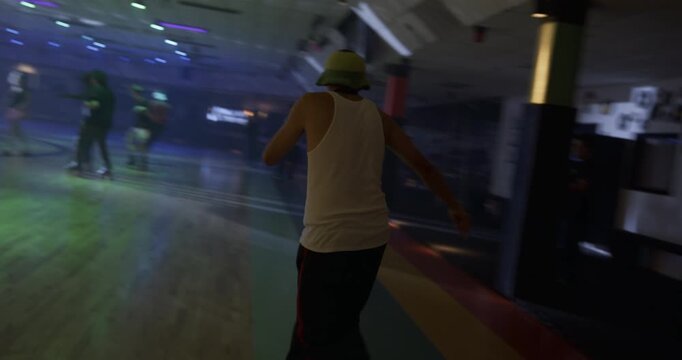 Young professional male skater stumbling but also doing fun moves on disco floor