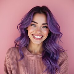 Fototapeta premium Young woman with bright purple wavy hair smiles broadly. She wears a pink knitted sweater against a soft pink backdrop. Her blue eyes are clear and bright.