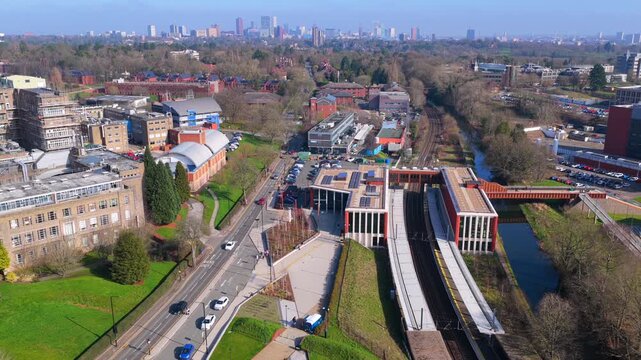 Aerial video of University train station next to Birmingham medical campus and city skyline on the Horizon. 