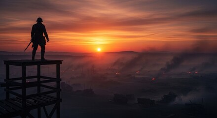 Fototapeta premium Silhouette of Watchtower During Fiery Sunrise Over Misty Landscape