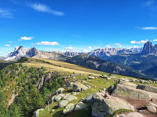 Naklejka premium Mountain landscape from Resciesa Dedora towards Mount seceda and Mount Pic against a blue summer background.