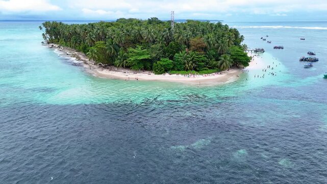Low altitude aerial drone footage approaching the white sand beach and lush tropical jungle of Cayo Zapatilla island in Bocas del Toro Panama.