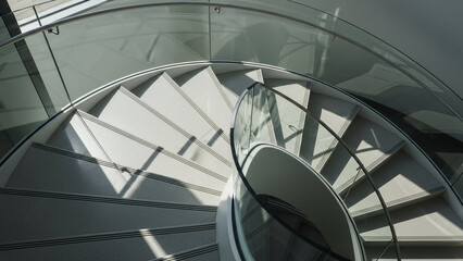 Obraz premium Spiral staircase in modern minimalist style with natural daylight and sleek metal railing for architectural design