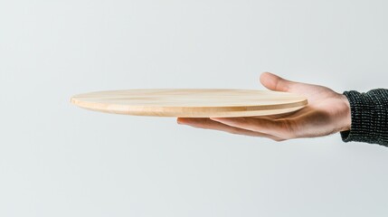Fototapeta premium A hand holding a wooden plate.