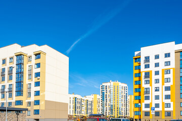 Modern Yellow and White Apartment Buildings in New Residential District Under Clear Blue Sky © Eugeniusz