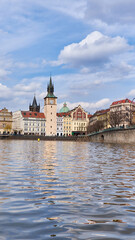 Fototapeta premium Charles Bridge reflected in Vltava river with Týn Church spires in background
