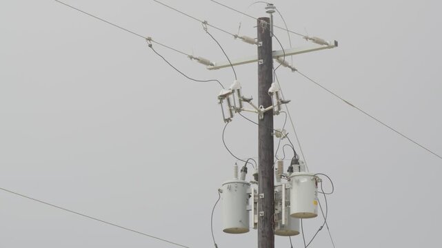 Utility power pole with transformers, insulators, cross-arm, wires