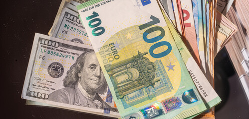 Obraz premium High-value global currencies close-up featuring US dollar and euro banknotes stacked together, symbolizing international finance, foreign exchange, banking, wealth, investment and global economy.
