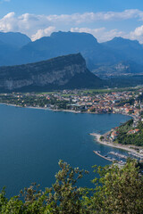 Fototapeta premium Lake garda town reflecting clear summer sky from mountain trail