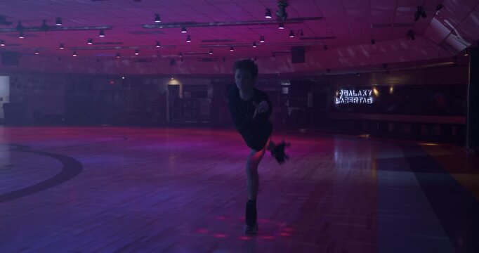 Young man doing epic, professional skating tricks on disco floor alone