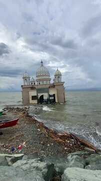 Slow motion view of the iconic floating mosque in Palu, Indonesia, partially submerged in the sea following the devastating 2018 earthquake and tsunami.